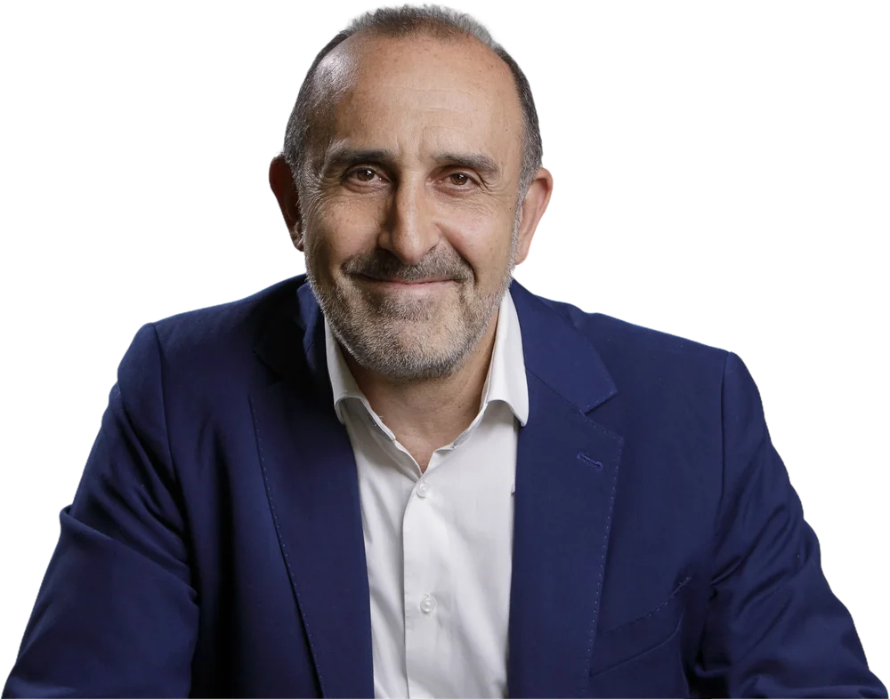 Elvio Rostagno sorride, con giacca blu e camicia bianca.